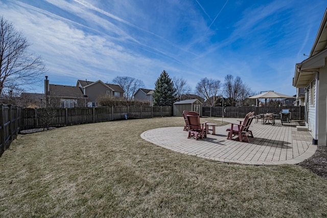 view of yard featuring a patio, a storage shed, an outbuilding, and a fenced backyard