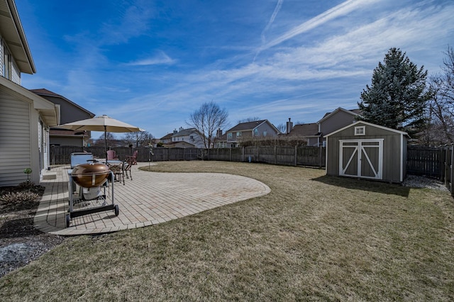 view of yard featuring an outdoor structure, a storage unit, a patio area, and a fenced backyard