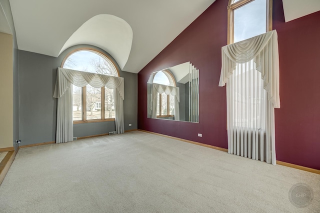 empty room with high vaulted ceiling, baseboards, and carpet floors