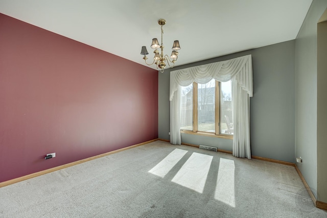 empty room with carpet flooring, visible vents, baseboards, and an inviting chandelier