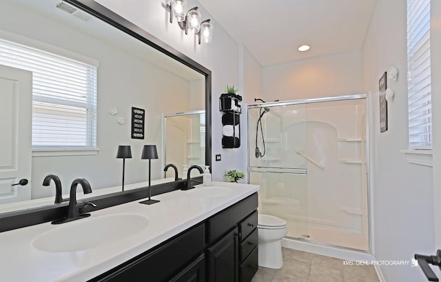 bathroom with a sink, visible vents, a stall shower, and tile patterned floors