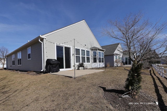 rear view of property with a lawn and a patio