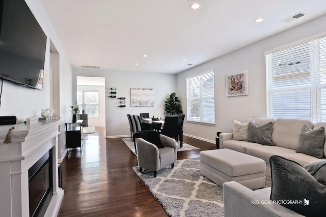 living room with recessed lighting, dark wood-style floors, visible vents, and baseboards