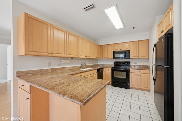 kitchen with visible vents, black appliances, light brown cabinetry, a sink, and a peninsula