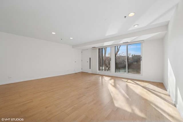 spare room with recessed lighting, light wood-style flooring, and baseboards