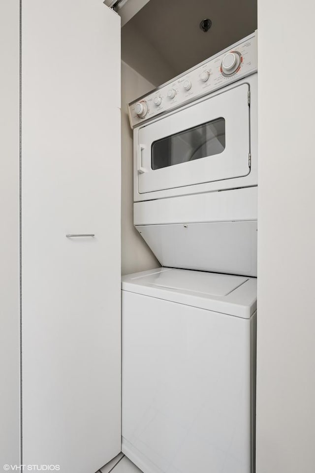 washroom with stacked washer and clothes dryer and laundry area