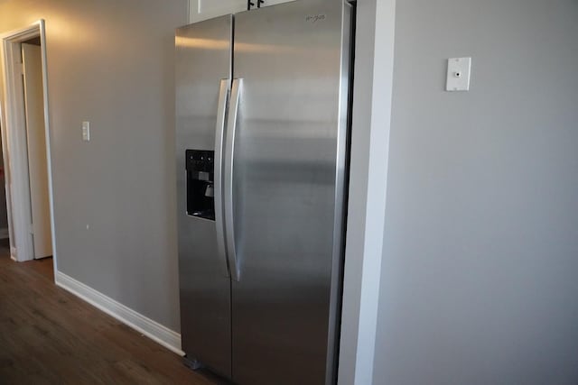 kitchen featuring baseboards, stainless steel fridge, white cabinets, and dark wood-style flooring