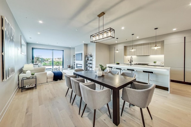 dining space with recessed lighting, light wood-type flooring, and baseboards