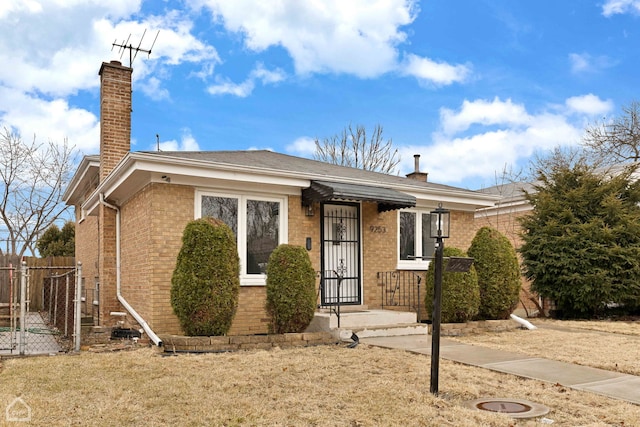 view of front of home with brick siding, a chimney, a gate, and fence