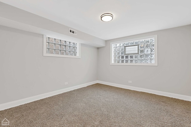 basement featuring visible vents, carpet floors, and baseboards