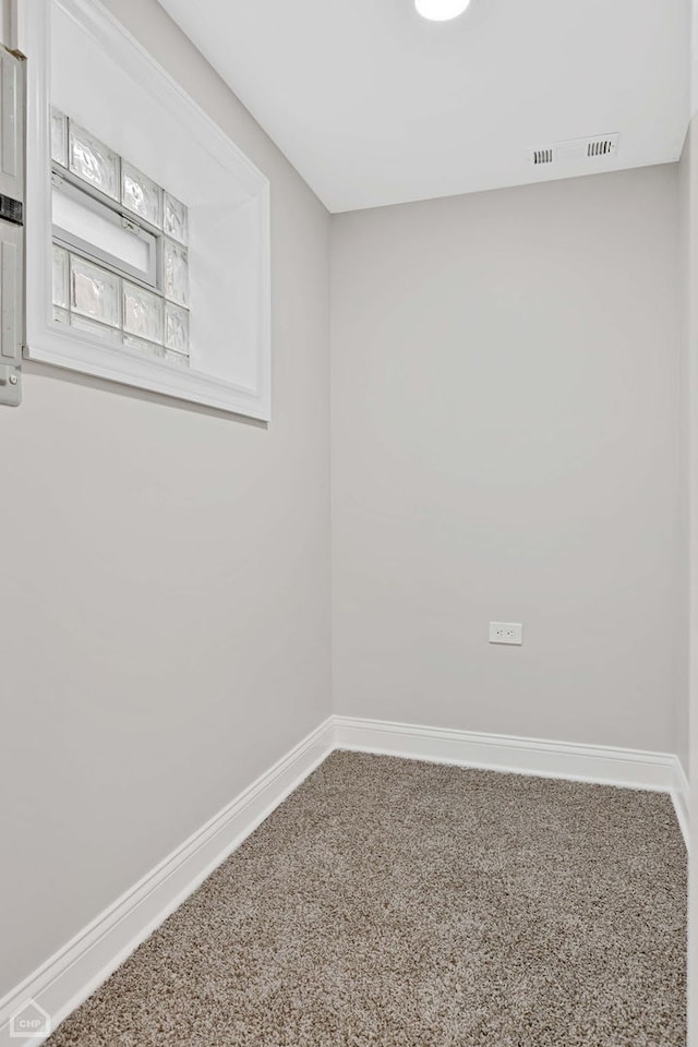 empty room with baseboards, carpet floors, and visible vents