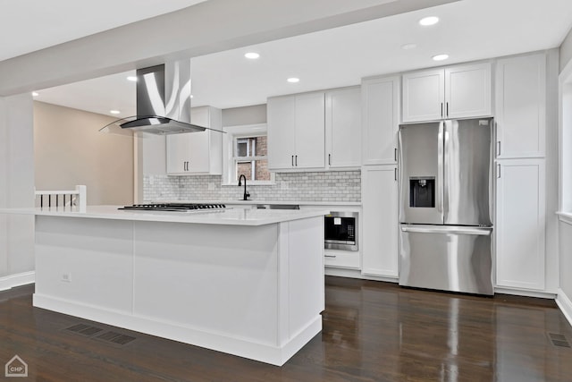 kitchen featuring dark wood-type flooring, island exhaust hood, visible vents, and appliances with stainless steel finishes