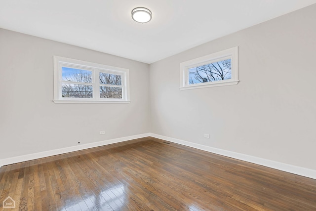 empty room featuring dark wood finished floors and baseboards