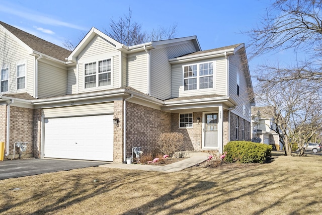 view of front of home featuring brick siding, driveway, a front lawn, and a garage