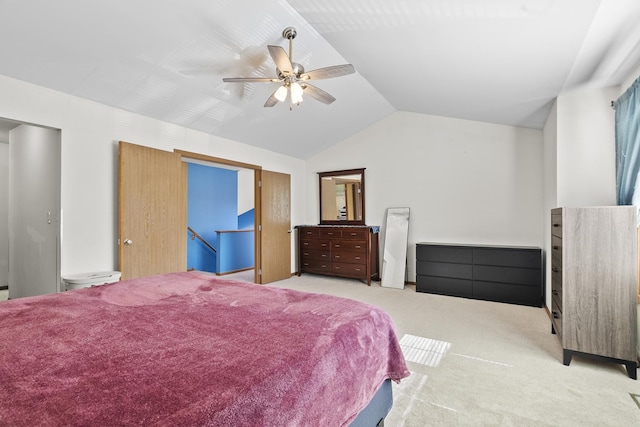 carpeted bedroom with vaulted ceiling and a ceiling fan