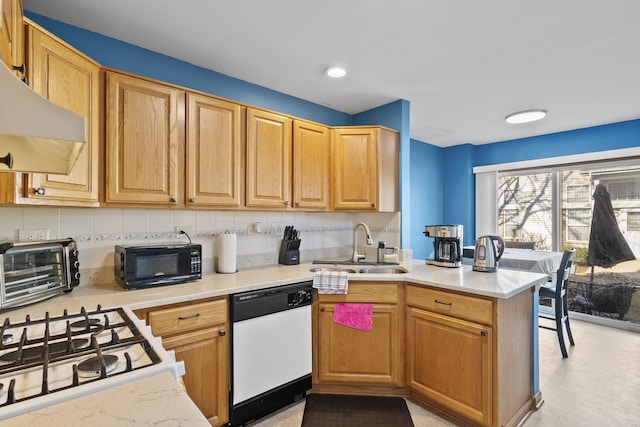 kitchen featuring a peninsula, a sink, extractor fan, black microwave, and dishwasher