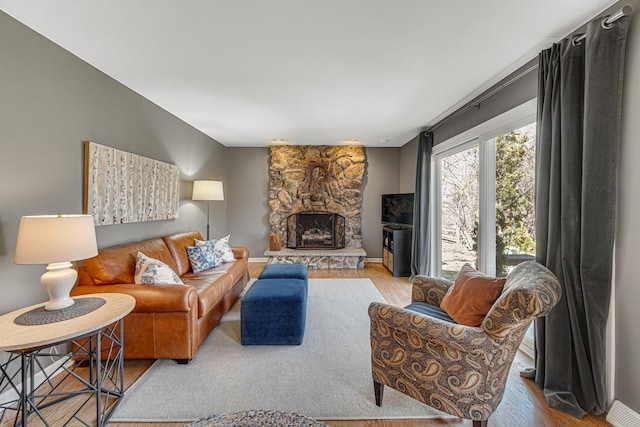 living room with wood finished floors and a fireplace