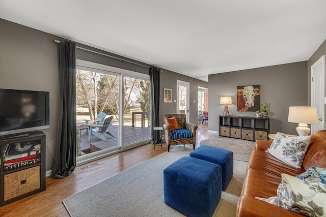 living room with wood finished floors, visible vents, and baseboards