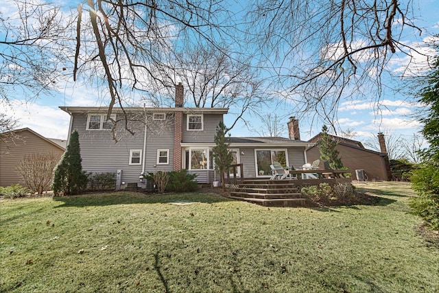 rear view of property featuring a wooden deck, a lawn, and a chimney