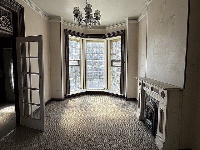 interior space with laundry area, baseboards, an inviting chandelier, and ornamental molding