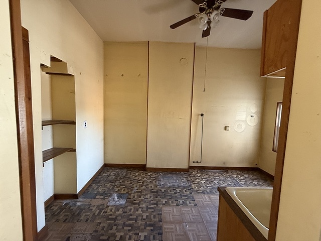 spare room featuring baseboards and ceiling fan