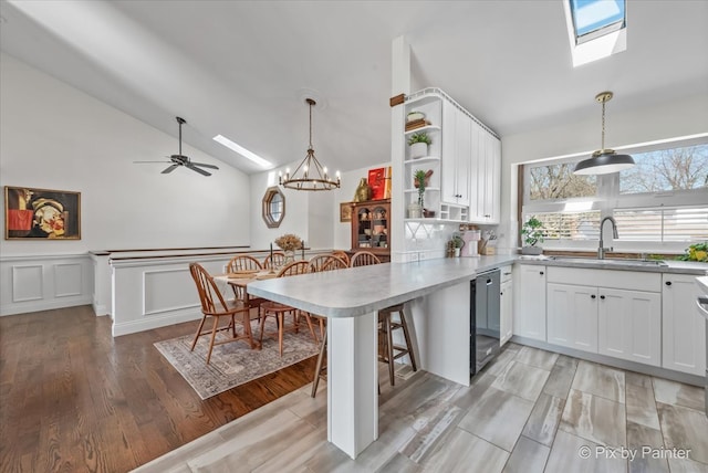 kitchen with a sink, open shelves, a peninsula, and white cabinets