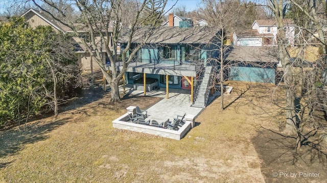 rear view of property with a deck, a patio, and a lawn