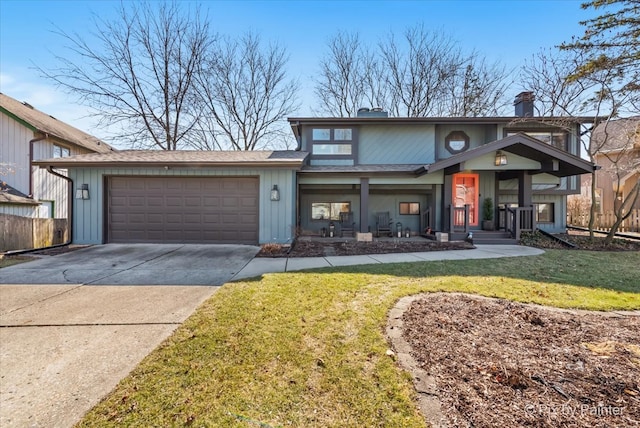 traditional-style house featuring a garage, a front yard, a chimney, and driveway