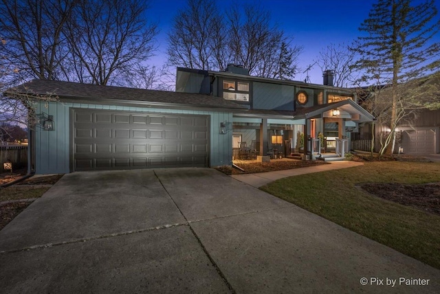 view of front of property with concrete driveway, fence, and a garage