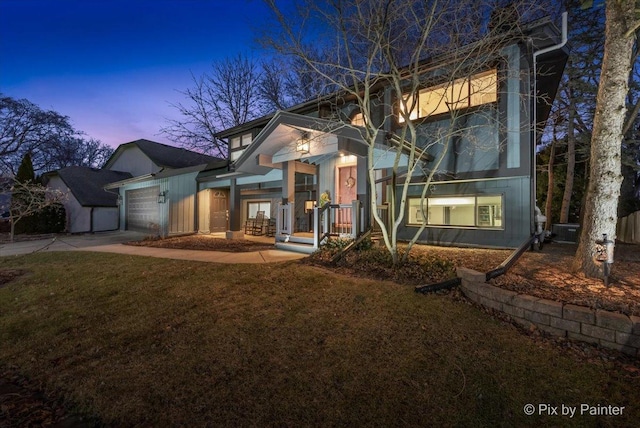 view of front facade featuring a garage, concrete driveway, and a front lawn