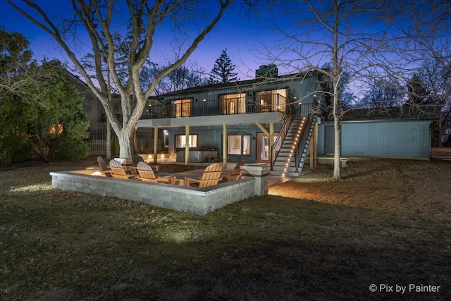 back of house with a patio area, a chimney, stairs, and an outdoor fire pit