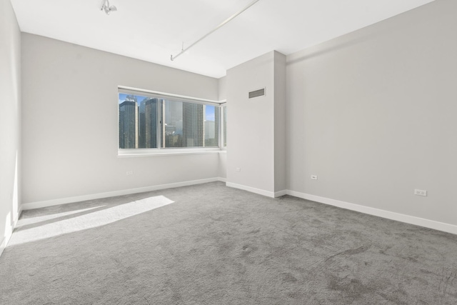 unfurnished room with visible vents, baseboards, and carpet floors