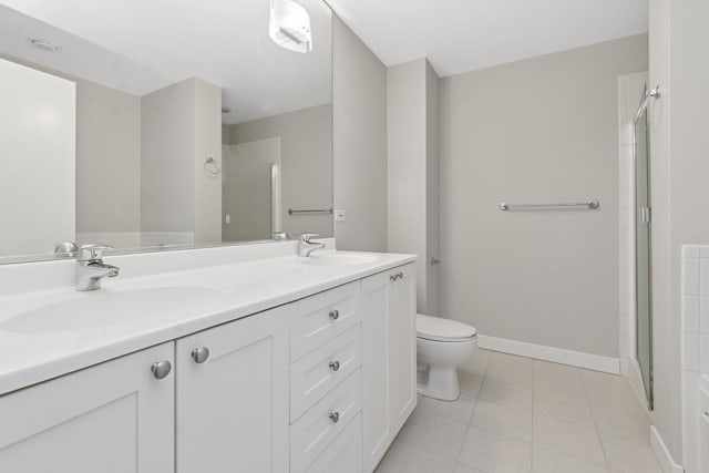 full bathroom featuring baseboards, a shower with shower door, a sink, tile patterned flooring, and toilet