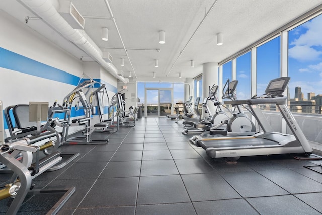 workout area with a textured ceiling, plenty of natural light, and expansive windows