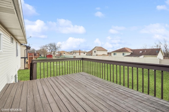 wooden deck with a lawn, a residential view, and a fenced backyard