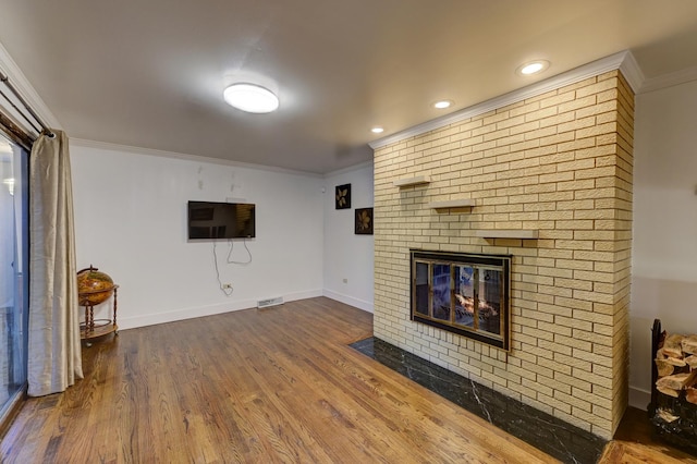 unfurnished living room with visible vents, baseboards, dark wood finished floors, a fireplace, and crown molding