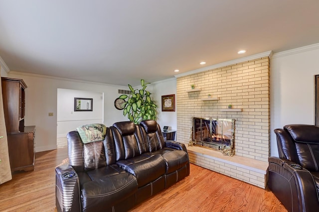 living area with a fireplace, crown molding, wood finished floors, and baseboards