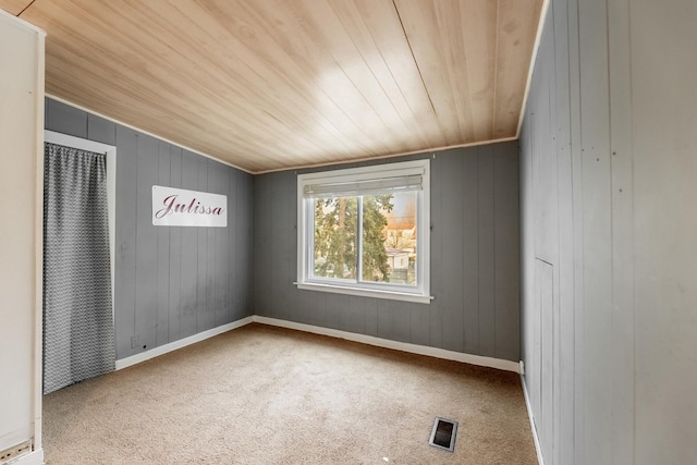 unfurnished room with visible vents, carpet flooring, and wooden ceiling