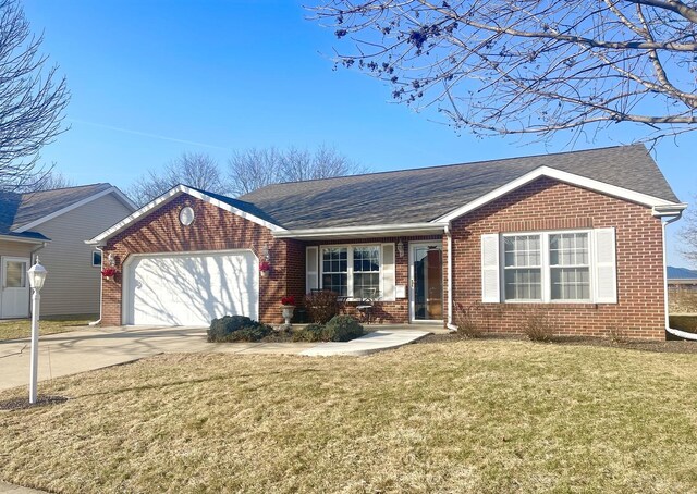 ranch-style home featuring a garage, brick siding, concrete driveway, and a front lawn