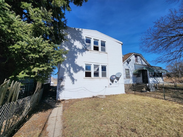 view of front of home with a front lawn and fence