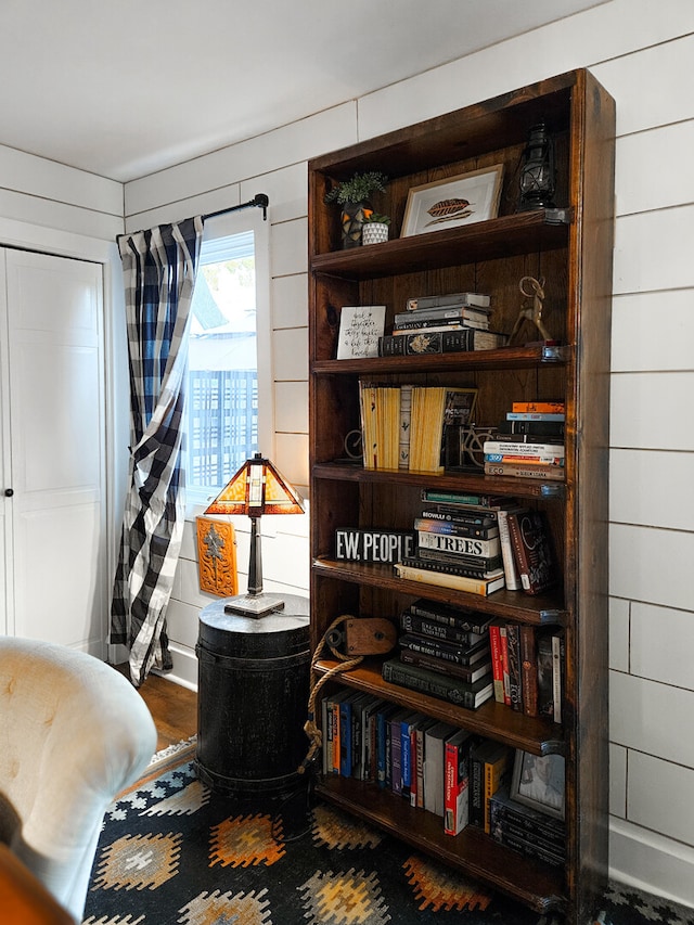 sitting room with wooden walls and wood finished floors