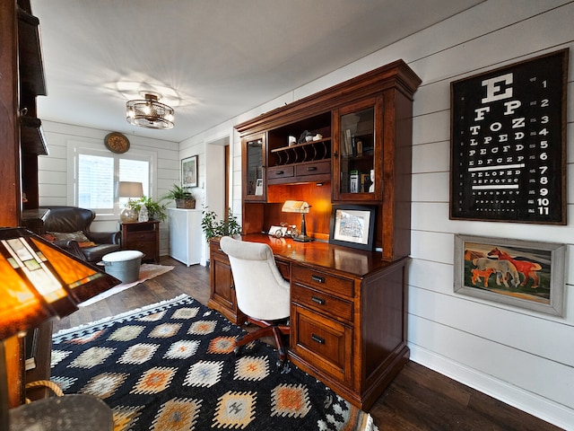 office area featuring dark wood-style floors, wooden walls, and baseboards