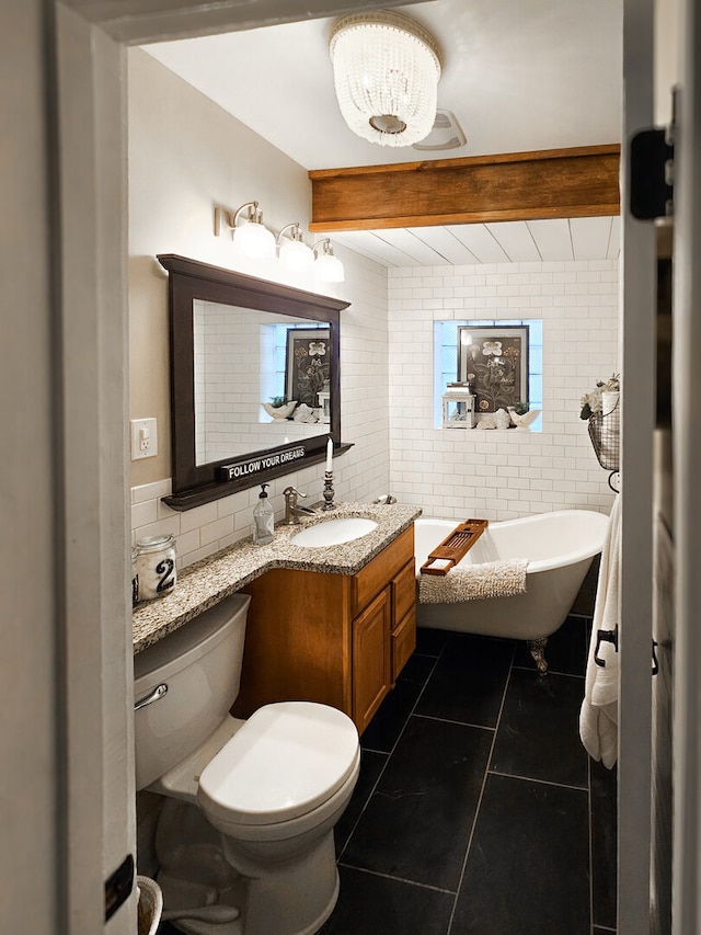 bathroom with vanity, toilet, tile walls, and a soaking tub