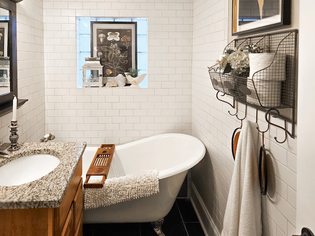 bathroom with vanity, tile walls, and a freestanding tub