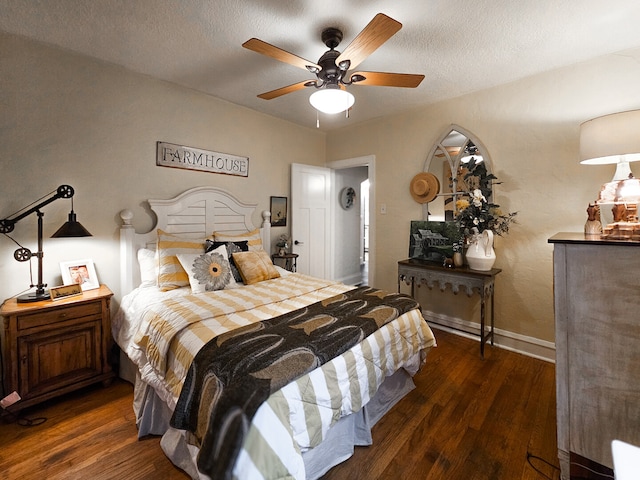 bedroom with ceiling fan, wood finished floors, baseboards, and a textured ceiling