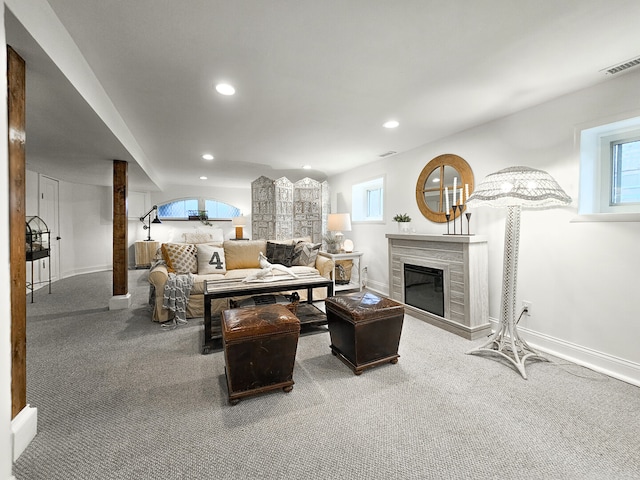 carpeted living area featuring recessed lighting, visible vents, baseboards, and a glass covered fireplace