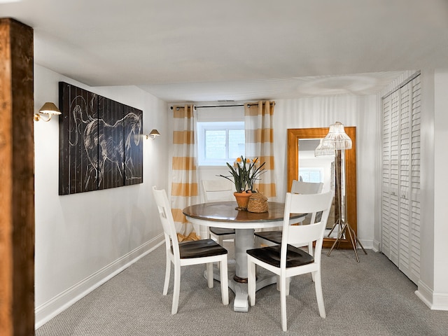 carpeted dining space featuring baseboards