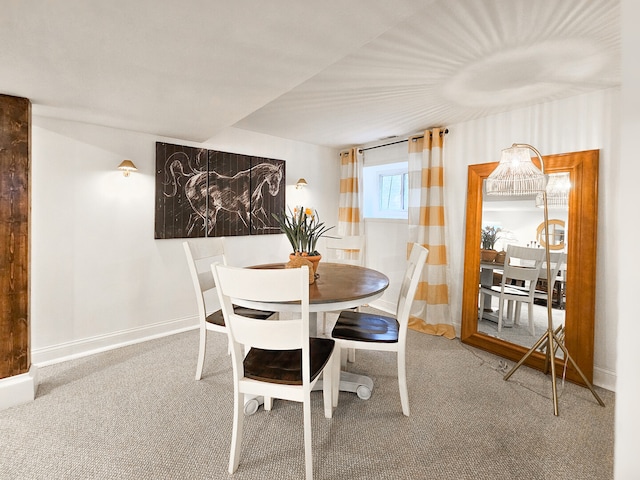 carpeted dining room with baseboards