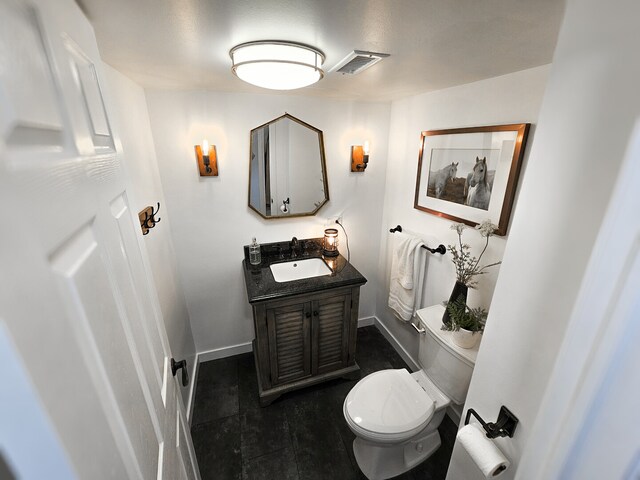 bathroom featuring visible vents, baseboards, toilet, and vanity