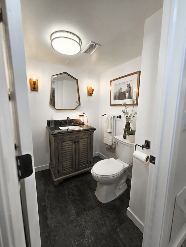 half bath featuring visible vents, baseboards, toilet, and vanity